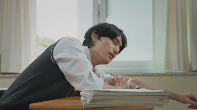 Student sleeping on a desk in a classroom