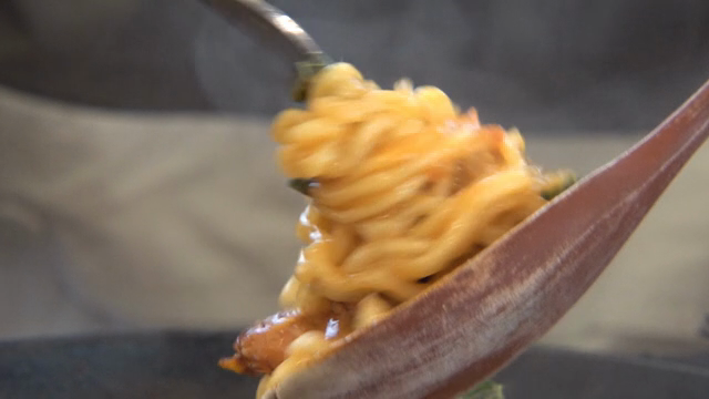 A scene of ramyeon being rolled on a fork