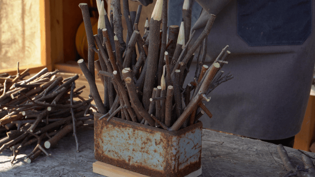 Woodcraft artisan arranging branches in a rusty container