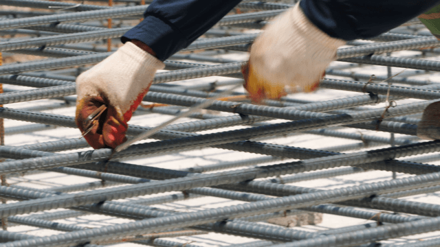 Worker tying rebar at a construction site