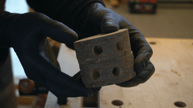 Craftsman closely inspecting a wooden piece with a hole
