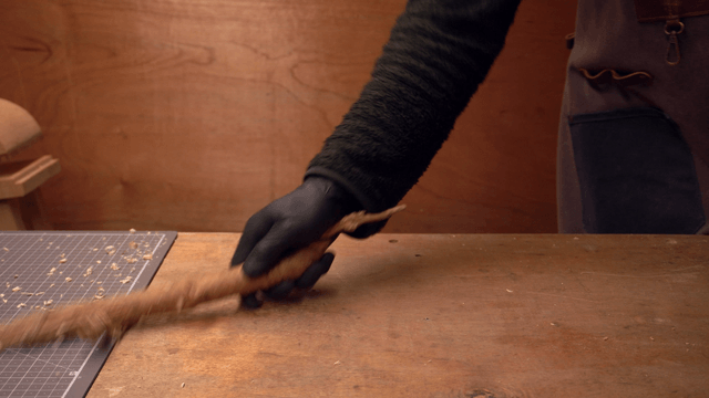 Person cleaning up sawdust in a cozy workshop