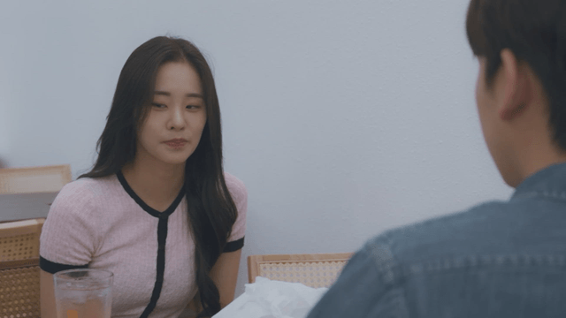 Woman smiling and talking to a man in a cafe
