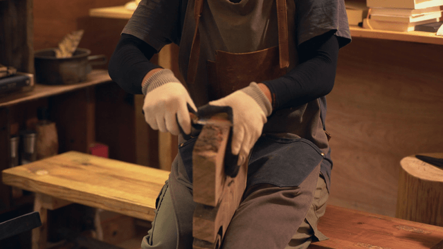 Craftsman working on a wooden piece indoors