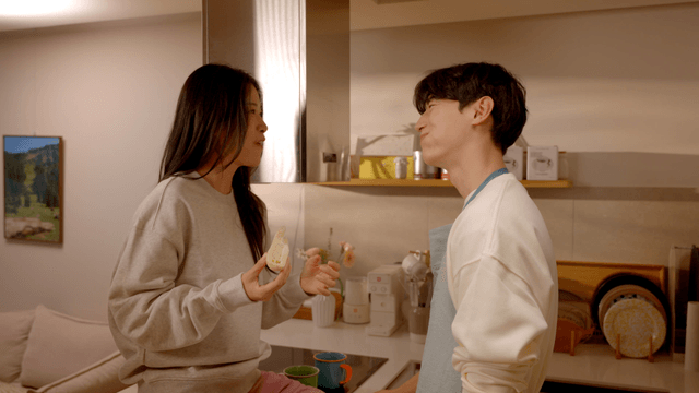 Couple having bread and coffee in kitchen