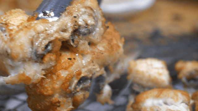 Sizzling eels grilling over charcoal fire