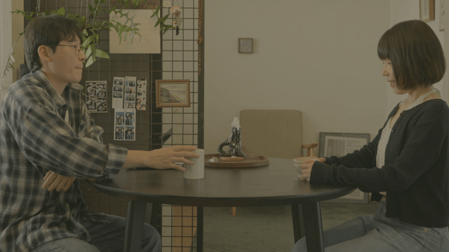 Two people talking at home dining table