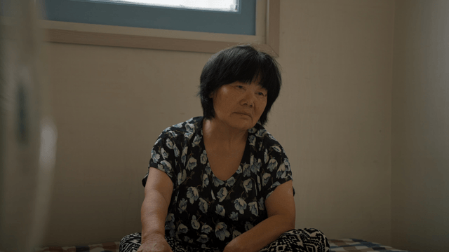 An elderly woman sitting indoors