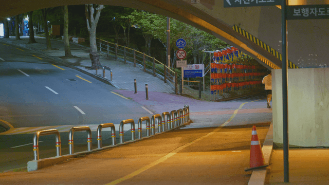Nighttime path under a bridge with a running man