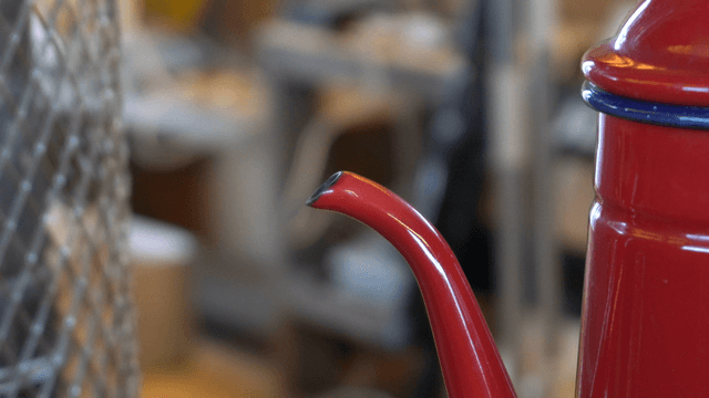 Steam rising from the spout of a red kettle