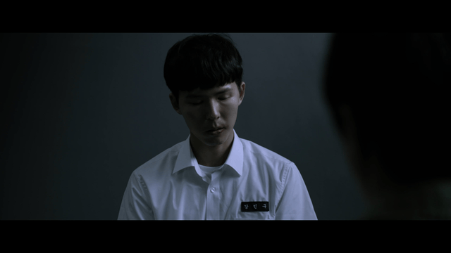 Male student being interrogated in dark room
