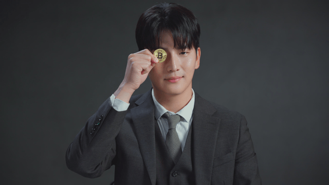 Man in a suit holding a Bitcoin coin