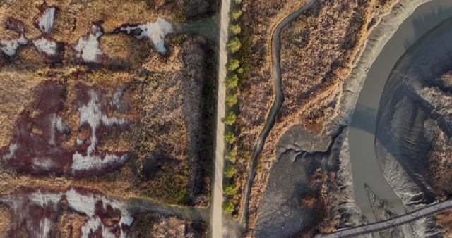 Aerial view of a winding path through a marshland