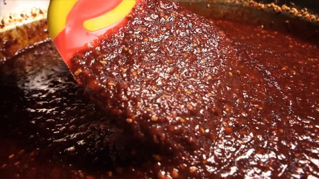 Red chili paste being stirred with a spatula