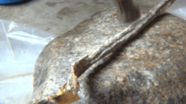Dried Fish Being Flattened with Hammer