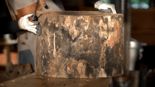 Artisan carving wooden surface with a chisel