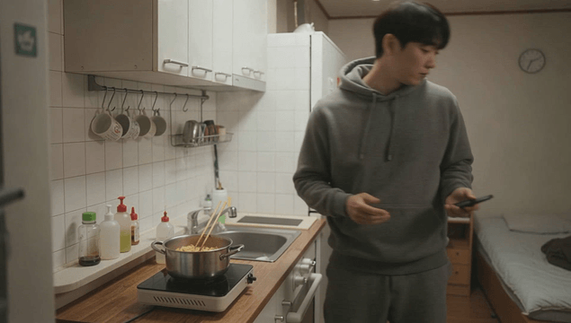 Young man cooking ramen in a studio sigle room
