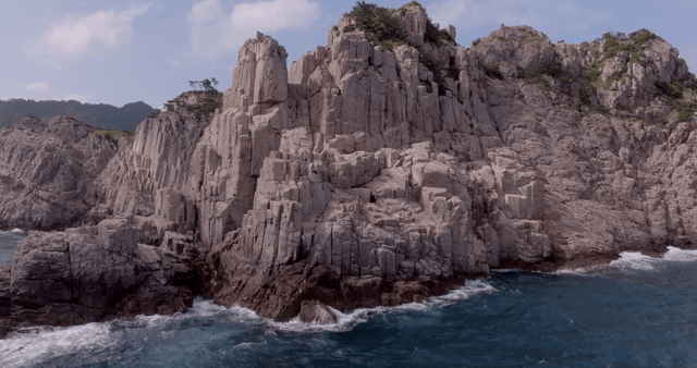 Rocky cliffs by the ocean with waves