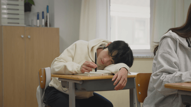 교실에서 책상에 엎드린 학생