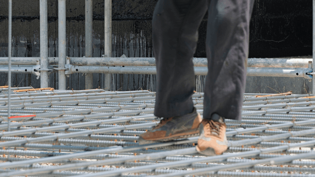 Construction worker tying rebar on site