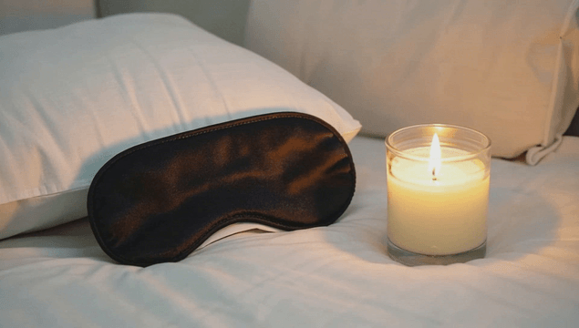 침대 위의 수면 안대와 양초