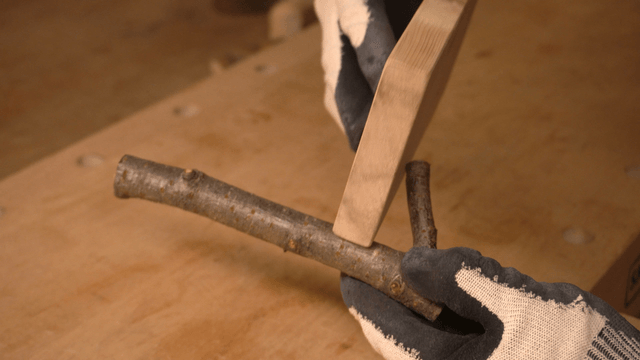 Hands delicately handling branches and wooden boards