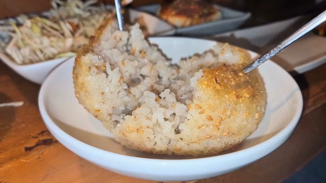 Grilled rice ball being split open