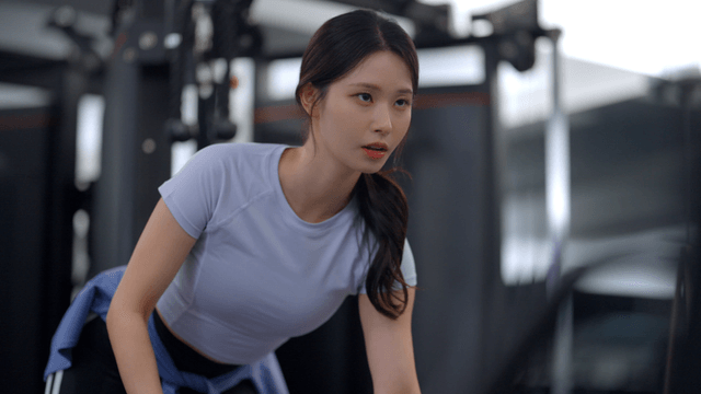 Young woman focused on a dumbbell row in the gym