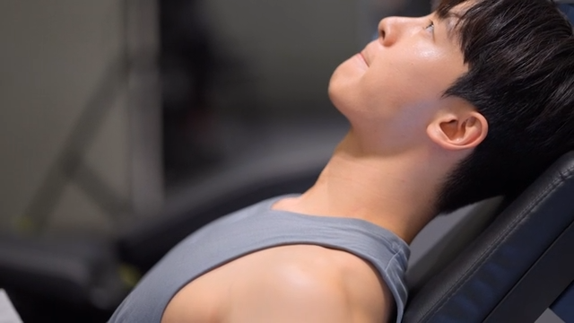 Young man exercising in a gym on a bench