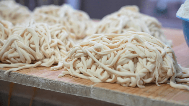 Freshly made noodles on a wooden board