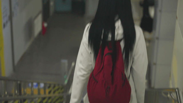 Young woman walking down subway stairs