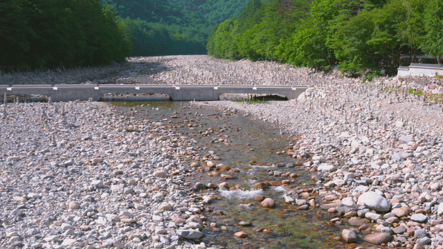 Clear stream flowing through gravel field