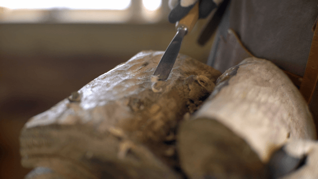 Woodcraft artisan carving wood with a chisel