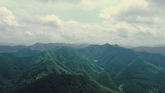 Lush green mountains under a cloudy sky