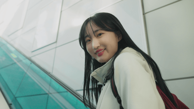 Smiling woman riding up on escalator