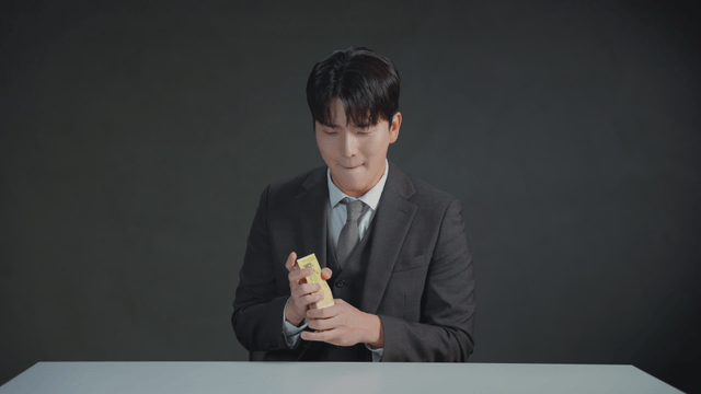 Man smelling money with a satisfied expression