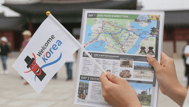 한국 지도와 환영 깃발을 들고 있는 관광객