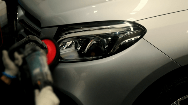 Car headlight being polished in a workshop