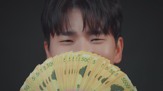 A person holding a fan of currency notes