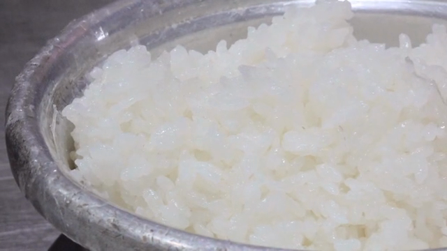 Steamed rice being stirred in a pot