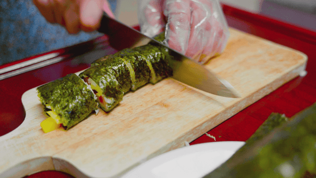 나무 도마 위에서 김밥을 자르는 모습