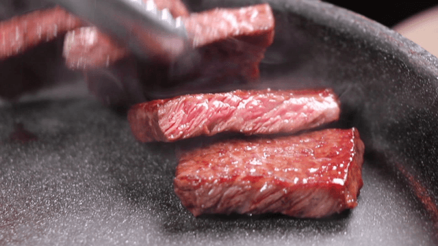 Sizzling beef cooking in a hot pan
