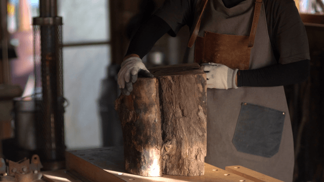 Woodcraft artisan handling a large log in workshop