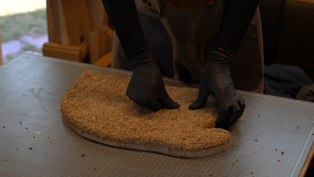 Woodcraft artisan pressing wood and sawdust firmly together