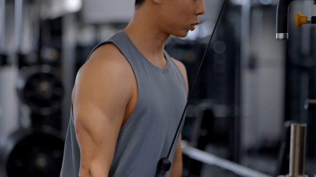 Man exercising with cable machine in gym
