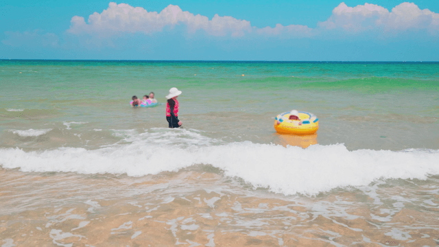 Children enjoying the sea on inflatable tubes at beach