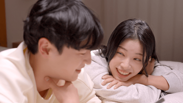 Couple smiling at each other on bed