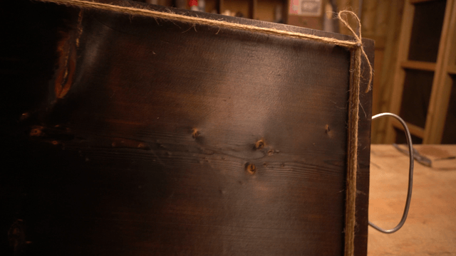 Black wooden board with nails and tied strings