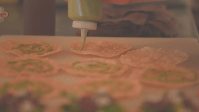 Green sauce spread on crispy tortilla