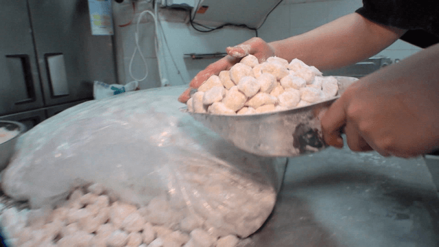 주방에서 반죽 조각들을 반죽 기계에 넣는 과정